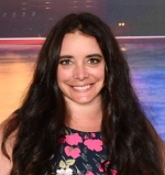 Professional headshot of Paula Simmons, wearing a floral top in front of a multicolor background.