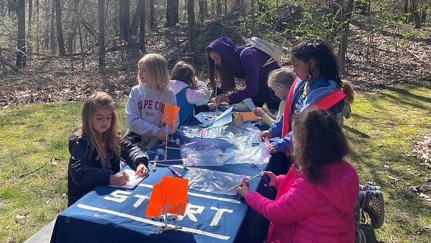 A group of young girl scouts working on an activity at a table.