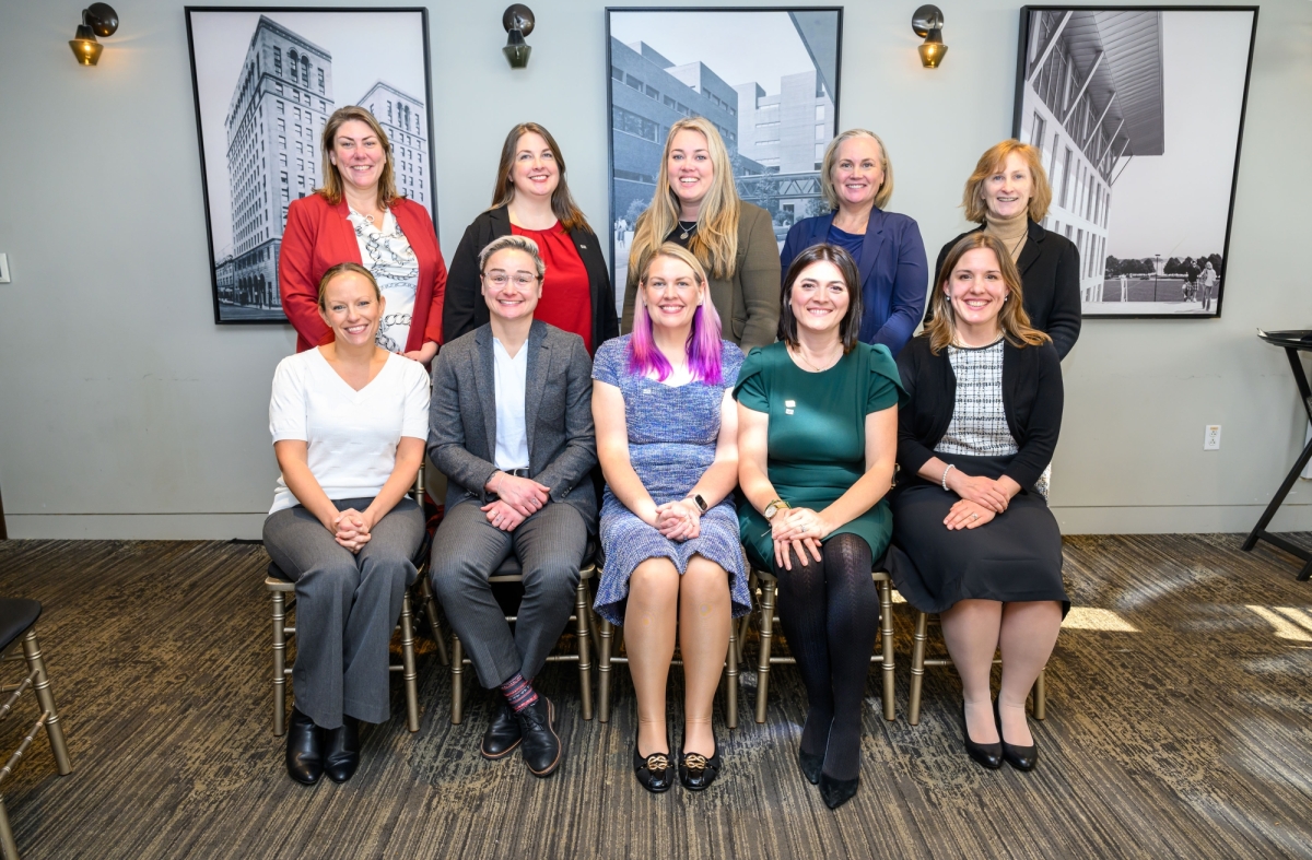 The members of the WTS-Boston 2025 Board of Directors posing, with the executive board members sitting in chairs, and 5 directors-at-large standing behind them.
