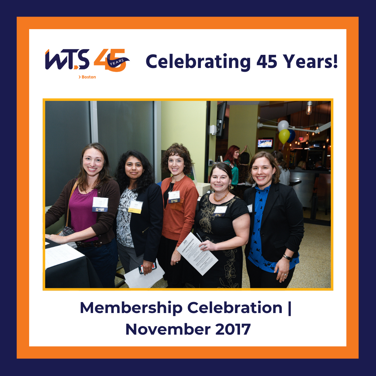 A photo of 5 women standing together and posing for the camera. Above is the WTS Boston 45th anniversary logo next to the words Celebrating 45 years in blue. Below the photo reads Membership Celebration November 2017 in blue text. A blue and orange border surrounds the entire post.
