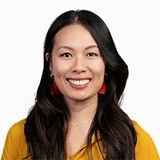 headshot of Lisa wearing a yellow top, with a white border around the photo