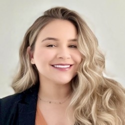 head-and-shoulders photo of a woman with long wavy hair wearing a dark blazer and light top