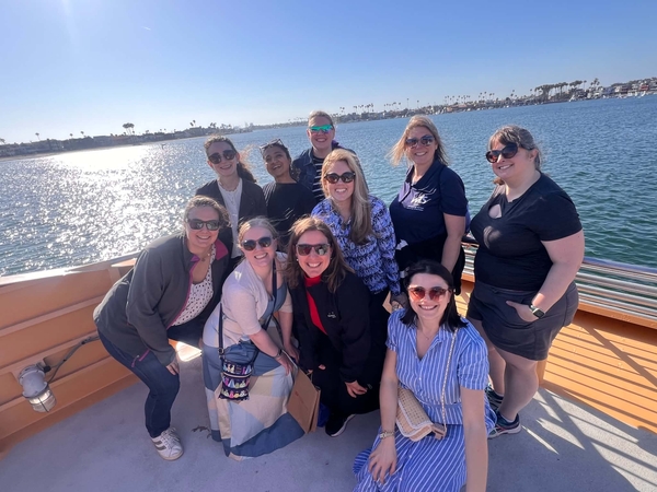 Group of women smiling on a boat with the water in the background