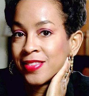Headshot of woman with hand on neck, red lipstick and hoop earrings