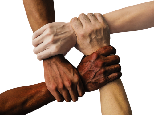 Photo of four people's hands interlocking.