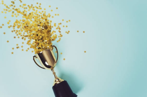 Trophy with confetti on blue background