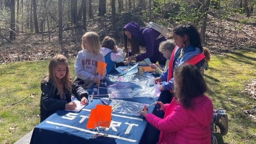A group of young girl scouts working on an activity at a table. 