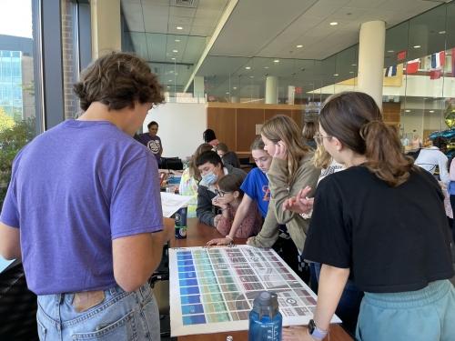 Volunteers run a transportation related board game with students at an expo event