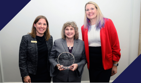 WTS-Boston President Gina Solman and Vice President Sarah Bergman posing with award winner Stephanie Pollack and her glass award