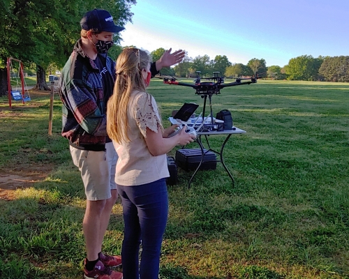 Student piloting drone with professional guidance