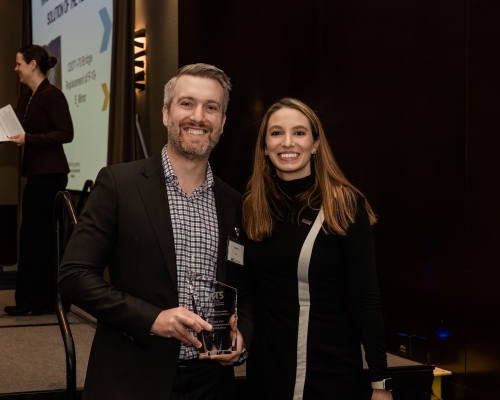 Man holding award next to woman