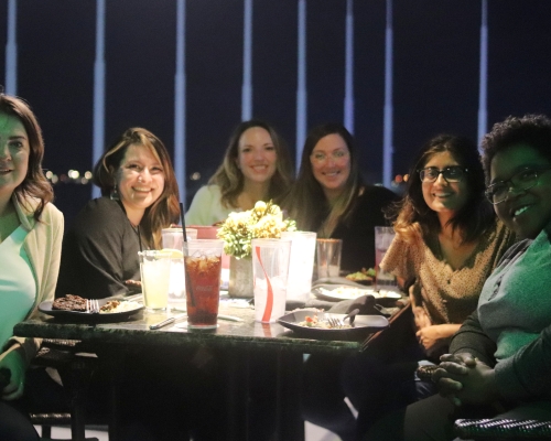 Group of people sit around a table at Topgolf