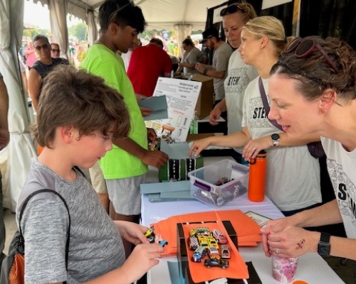 Photo of children visiting the WTS booth on STEM day at Iowa State Fair 2023