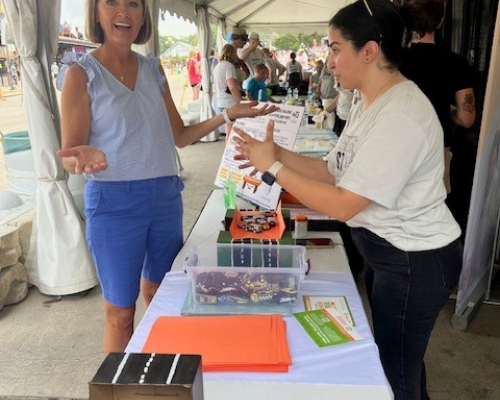 Photo of Governor Kim Reynolds visiting the WTS booth on STEM day at Iowa State Fair 2023