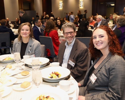 A group of WTS members smiling at a table