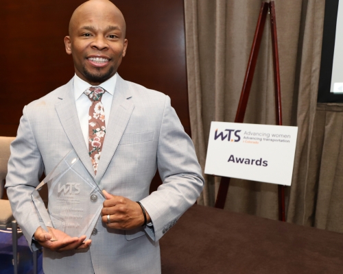 Award recipient posing for a photo with his award. 