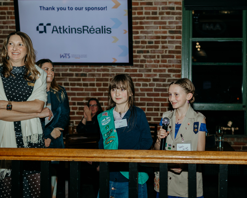Two girls scouts and a WTS member speaking to the group at the annual awards gala.