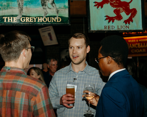 A group of three chatting at the annual awards gala. 