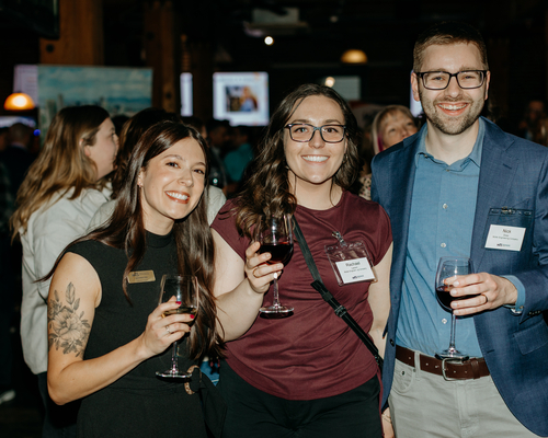 Three people smiling while at the annual awards gala. 