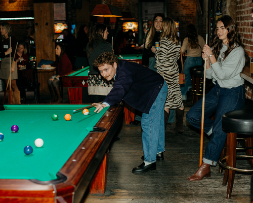 People playing pool at the annual awards gala. 