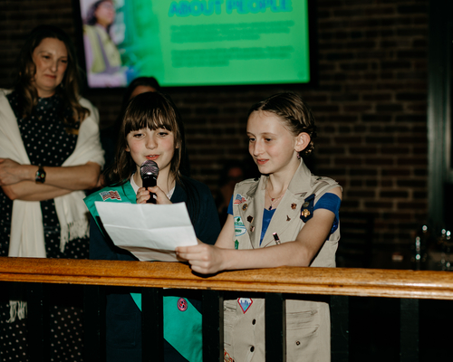 Two girl scouts presenting at the annual awards gala. 