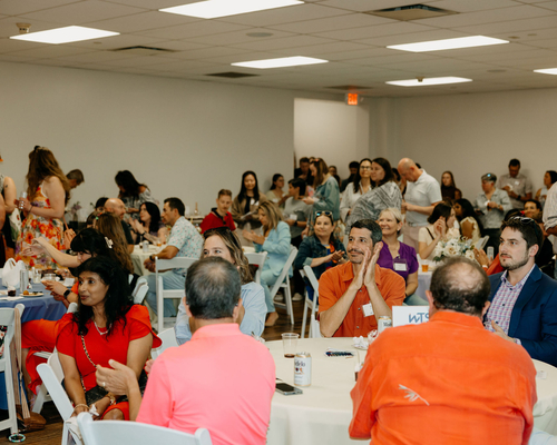 Large group of people sitting and applauding during the summer social. Photos by Brooke Silverman