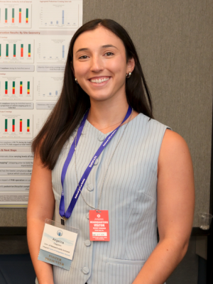 Headshot of Angelina Caggiano wearing a light gray vest in an academic setting.