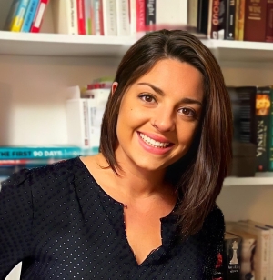 Headshot of Amanda Barlow in a black top in front of a bookcase.