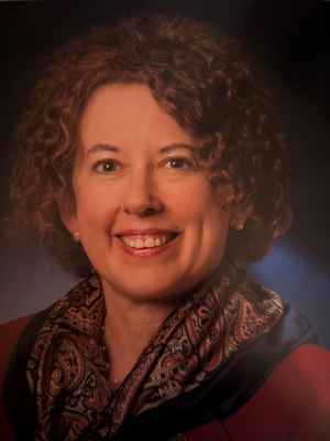 Headshot of Abbie Goodman, a woman with curly brown hair, the recipient of the WTS Boston Leadership Award.