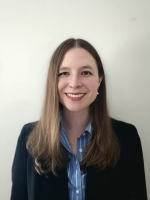 Woman smiling with long brown hair in a black blazer