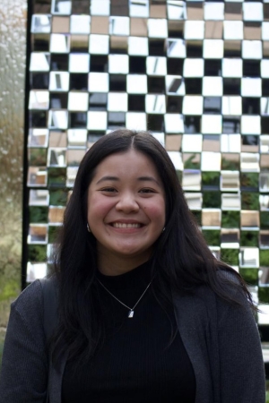 Woman smiling with long brown hair in a black blazer